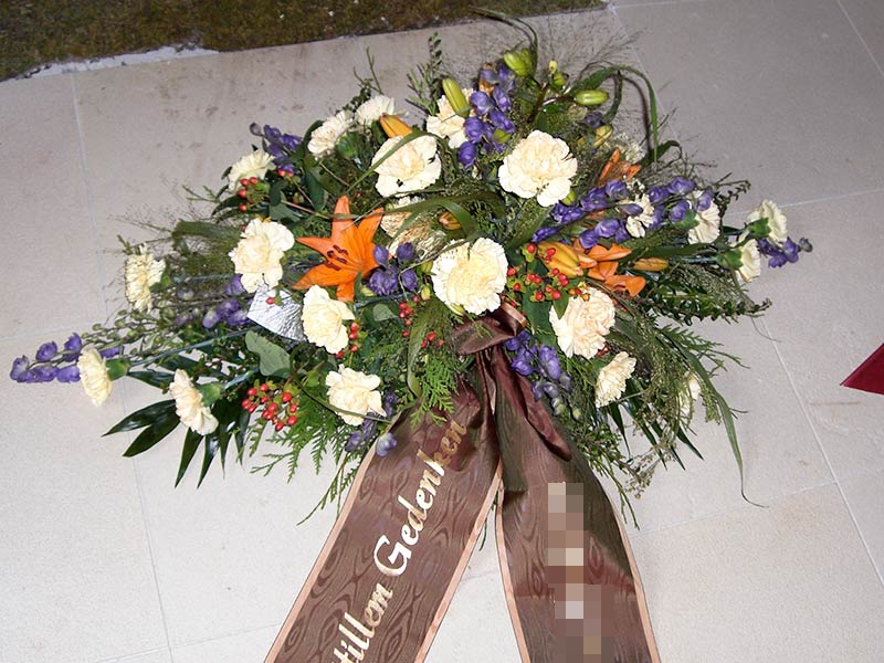 Gesteck flach orange-blau-creme